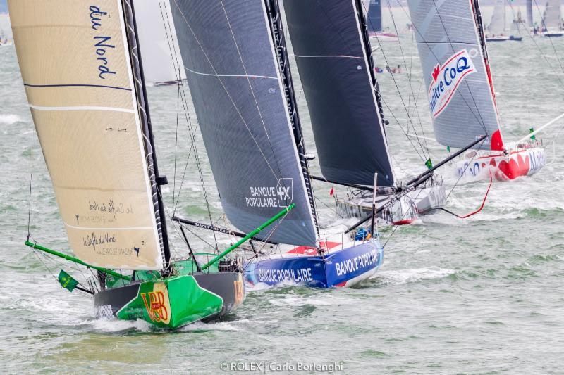 Heading off for their first night at sea, the largest fleet of IMOCA 60s to ever compete in the Rolex Fastnet Race made a spectacle at the start in the Solent - photo © Rolex / Carlo Borlenghi