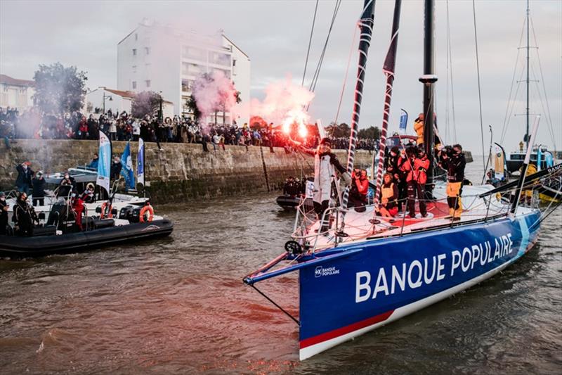 kipper Clarisse Cremer, Banque Populaire X, is pictured celebrating with flares in the channel during arrival of the Vendee Globe sailing race, on February 2 photo copyright Jean-Louis Carli / Alea taken at  and featuring the IMOCA class