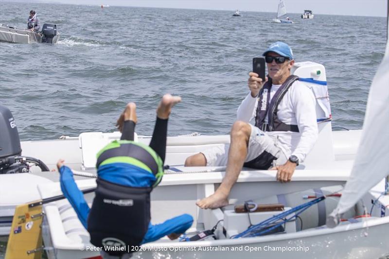 Regatta winner Joel Beashel celebrates his win with a flip into the water as his coach watches on - 2020 Musto Optimist Australian and Open Championship photo copyright Peter Withiel taken at Royal Yacht Club of Victoria and featuring the Optimist class