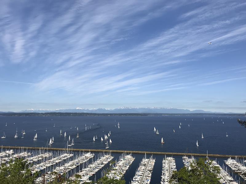 Yachts assemble off of Seattle Shilshole Bay Marina for the start of a distance race under clear skies, with the Olympic Mountains to the west photo copyright Coreen Schmidt taken at Corinthian Yacht Club of Seattle and featuring the PHRF class