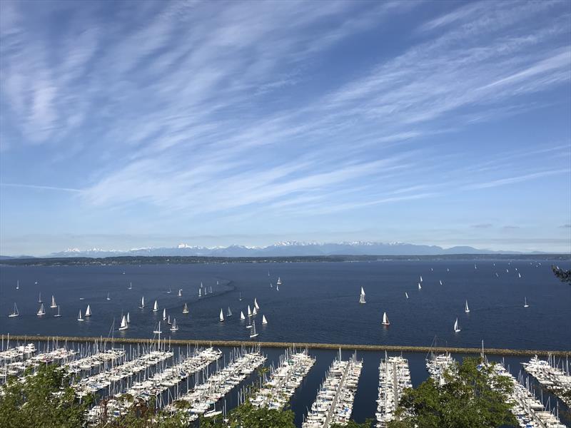 Yachts assemble off of Seattle Shilshole Bay Marina for the start of a distance race under clear skies, with the Olympic Mountains to the west photo copyright Coreen Schmidt taken at Corinthian Yacht Club of Seattle and featuring the PHRF class