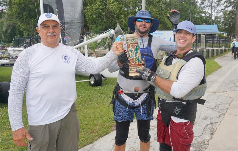 Larry Wagner, Commodore, presents the ritual mug of beer to Pete Hampshire and skipper Eric Roberts, winner of the 69th Mug Race photo copyright Image courtesy of the Mug Race taken at The Rudder Club of Jacksonville and featuring the PHRF class