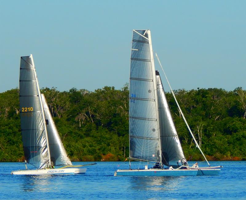 An Aquarius Roberts Catamaran 22 (ARC 22, left) and a Roberts Catamaran 27 (RC27, right) search for breeze in the early morning of the 67th annual Mug Race photo copyright The Mug Race taken at The Rudder Club of Jacksonville and featuring the PHRF class