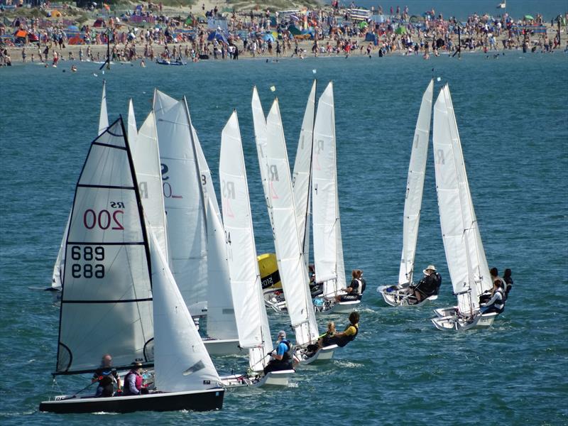 RS200s at the windward mark on Friday, with the crowds on West Wittering beach in the background at Chichester Harbour Race Week - photo © Liz Sagues