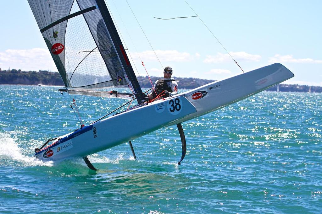 Glenn Ashby does a foil jump as he crosses the finish line to win the 2014 Int. A-Class Catamaran Worlds, Takapuna, NZ He has won nine world titles in the now foiling singlehander. - photo © Richard Gladwell www.photosport.co.nz