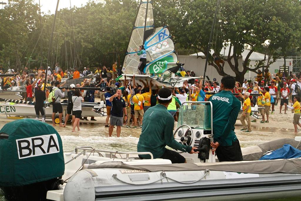 Martine Grael and Kahena Kunze (BRA) are given a heroines' welcome as they come ashore in Brazil after winning the Gold Medal in the 49errFX class on the last leg of the course. 206 Olympic Sailing Regatta photo copyright Richard Gladwell www.photosport.co.nz taken at  and featuring the  class