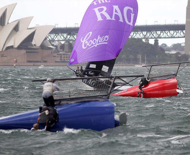 The Rag and Famish Hotel team takes the race lead as the Yandoo and Smeg teams try to right their skiffs - photo © Frank Quealey