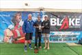 William Mason receives the Sir Peter Blake Memorial Trophy from renowned broadcaster Peter Montgomery (left) and last year's recipient Sean Kensington © LiveSailDie