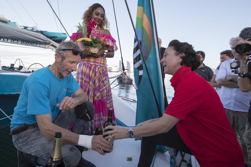 The wife of Lalou offers a bottle of wine to Antoine to thank him for picking up her husband after he capsized in his Multi 50 before being transferred to a tug in the Route du Rhum-Destination Guadeloupe photo copyright Alexis Courcou taken at  and featuring the Trimaran class