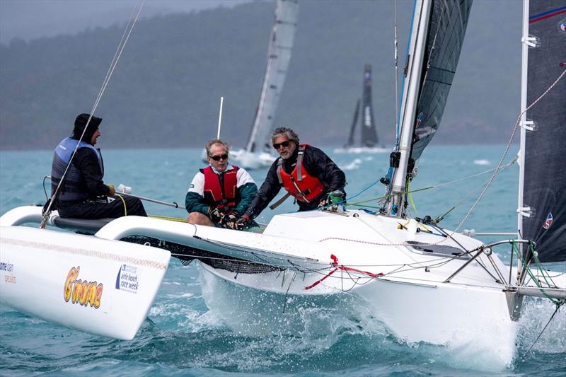 Terry Archer (black hood with blue top jacket) at the helm of his G'Nome at Airlie Beach Race Week photo copyright Andrea Francolini, ABRW taken at Whitsunday Sailing Club and featuring the Trimaran class
