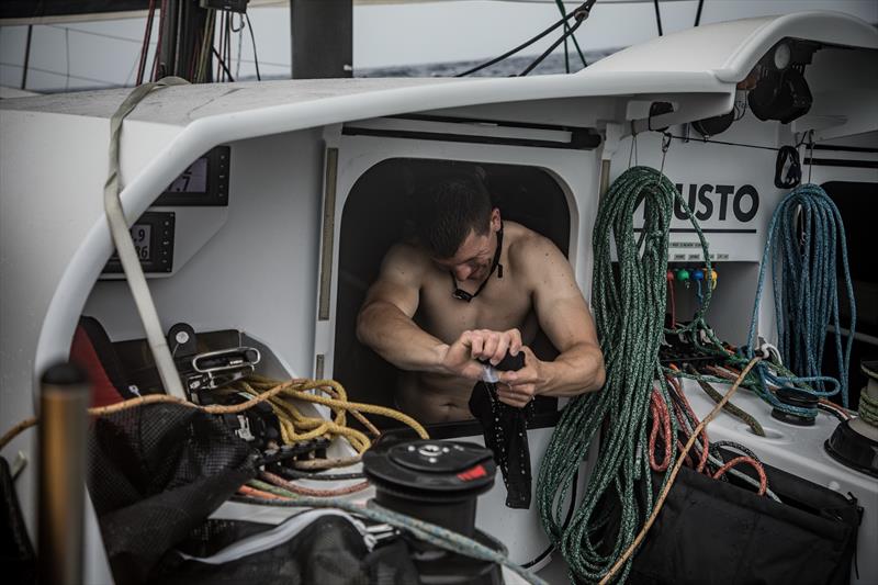 Onboard team Brunel Carlo Huisman tries to dry out some of his kit - photo © Martin Keruzore / Volvo Ocean Race
